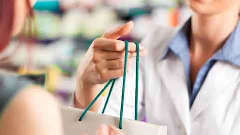 pharmacist handing over the shopping bags
